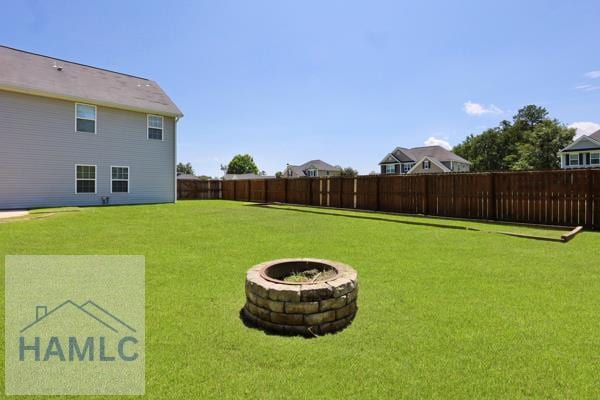 246 Cumberland Dr NE, Ludowici, GA 31316 - fenced backyard featuring an outdoor fire pit