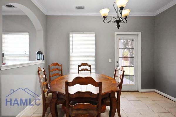 246 Cumberland Dr NE, Ludowici, GA 31316 - dining area featuring ornamental molding, a chandelier, arched walkways, and light tile patterned flooring