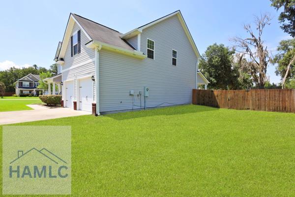 246 Cumberland Dr NE, Ludowici, GA 31316 - view of side of home featuring an attached garage and concrete driveway