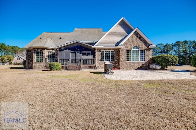 86 Brigham Dr, Richmond Hill, GA 31324 - rear view of property with brick siding, a patio area, and a lawn