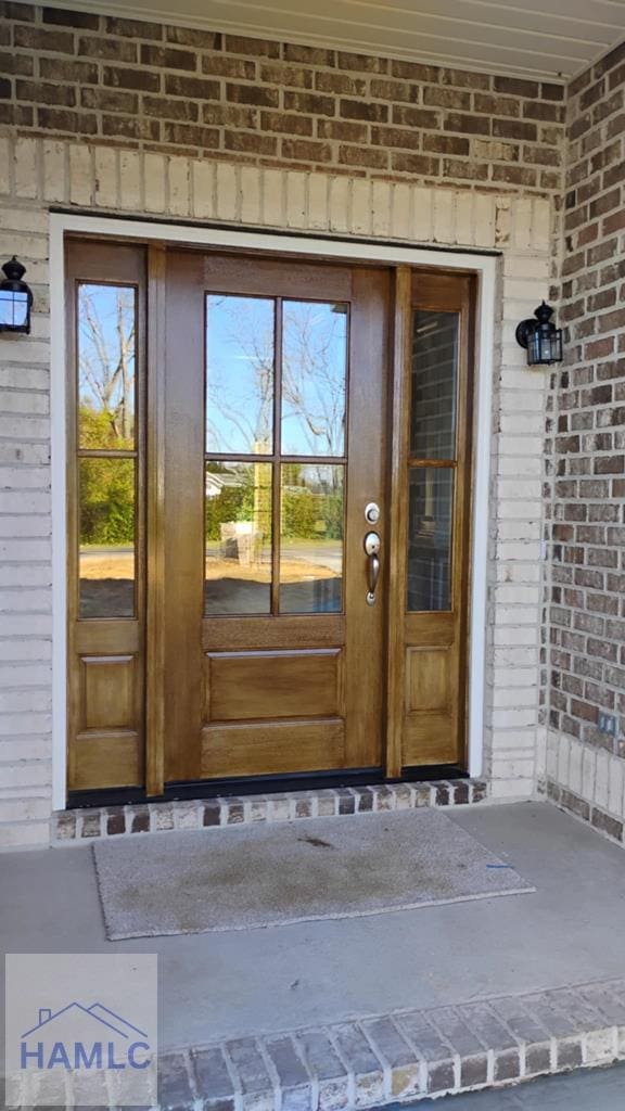 doorway to property with brick siding