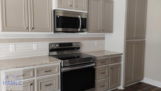 kitchen featuring light stone counters, baseboards, tasteful backsplash, and stainless steel appliances