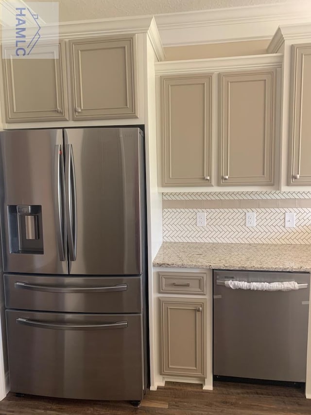 kitchen featuring light stone counters, appliances with stainless steel finishes, cream cabinetry, and decorative backsplash