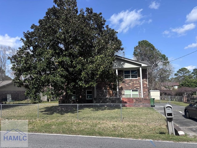 view of front of house featuring brick siding, a fenced front yard, and a front yard