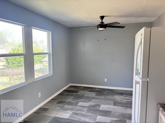 empty room with baseboards and a ceiling fan