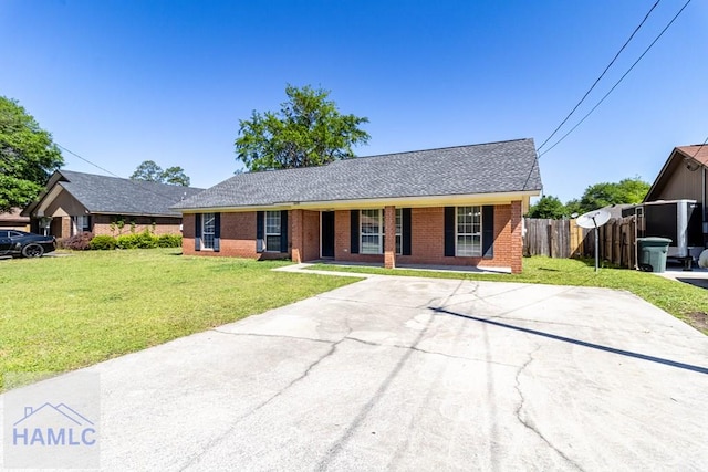 ranch-style home with a front yard, fence, brick siding, and a shingled roof