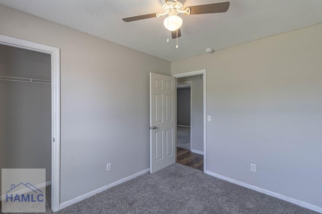 unfurnished bedroom featuring baseboards, carpet floors, a closet, a textured ceiling, and a ceiling fan