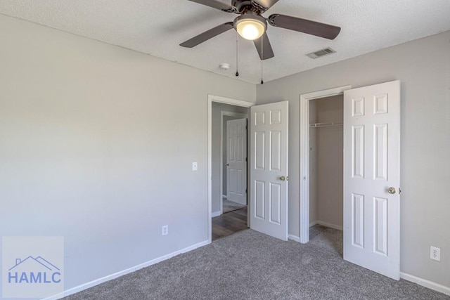 unfurnished bedroom with visible vents, baseboards, carpet floors, a closet, and a textured ceiling