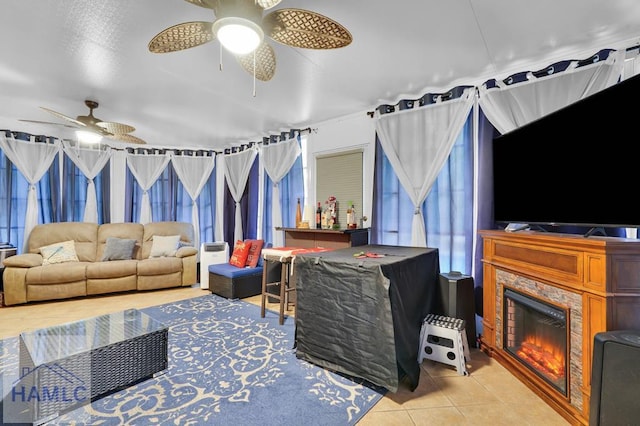 living room featuring ceiling fan, light tile patterned floors, and a fireplace