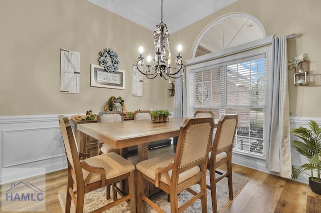 dining room with wood-type flooring and an inviting chandelier