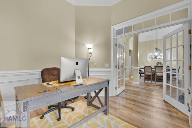 home office with a chandelier, ornamental molding, french doors, and light wood-type flooring