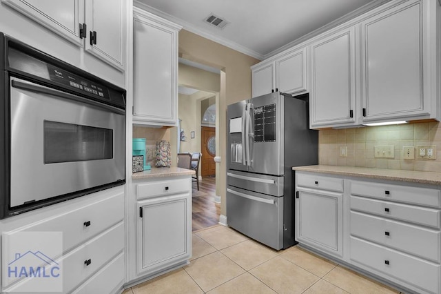 kitchen featuring white cabinets, stainless steel appliances, and light tile patterned floors