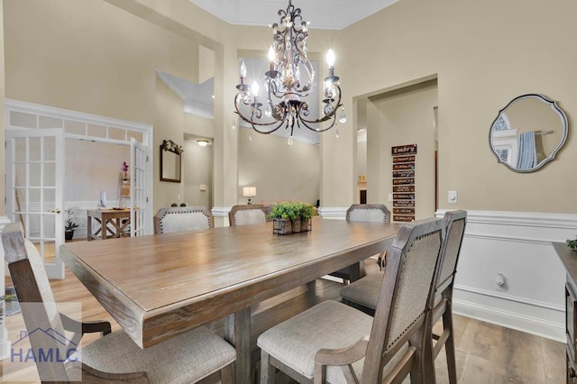 dining area with crown molding, hardwood / wood-style floors, and a chandelier