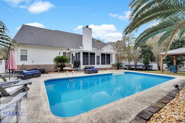 view of pool featuring a sunroom, a gazebo, outdoor lounge area, and a patio