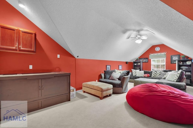 home theater with ceiling fan, a textured ceiling, lofted ceiling, and light carpet