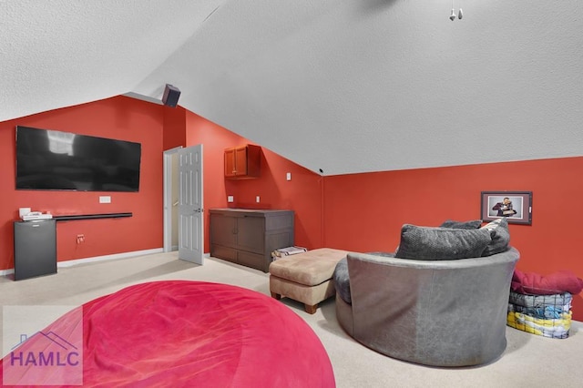 carpeted cinema room with a textured ceiling and vaulted ceiling