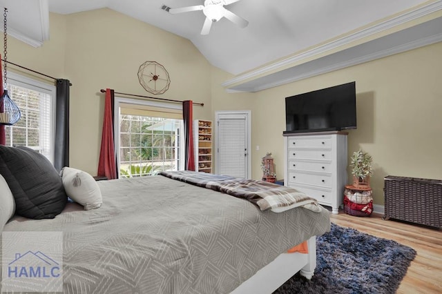 bedroom with ceiling fan, lofted ceiling, multiple windows, and wood-type flooring