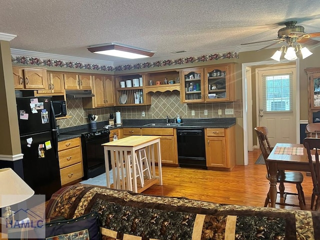 189 Sooner Dr, Jesup, GA 31545 - kitchen featuring black appliances, under cabinet range hood, ceiling fan, a sink, and light wood-style floors