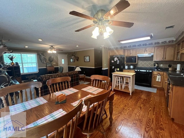 189 Sooner Dr, Jesup, GA 31545 - dining area featuring a textured ceiling, wood finished floors, a ceiling fan, ornamental molding, and a wainscoted wall