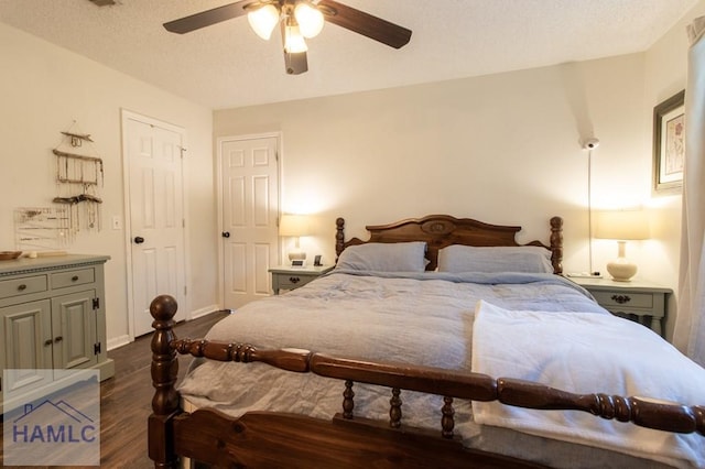 bedroom with baseboards, a ceiling fan, dark wood finished floors, and a textured ceiling