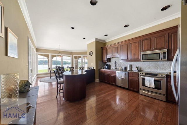 745 Chickasaw Trl, Sparta, GA 31087 - kitchen with stainless steel appliances, dark wood-style floors, tasteful backsplash, a kitchen breakfast bar, and ornamental molding