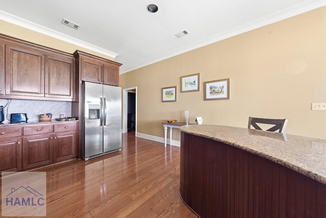 745 Chickasaw Trl, Sparta, GA 31087 - kitchen featuring stainless steel fridge with ice dispenser, crown molding, wood finished floors, tasteful backsplash, and baseboards