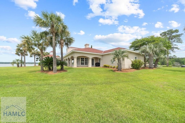 745 Chickasaw Trl, Sparta, GA 31087 - rear view of property featuring a lawn, a water view, a chimney, and stucco siding