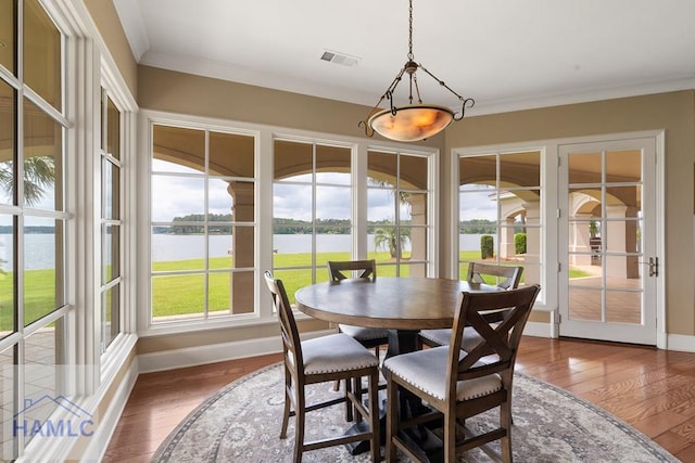 745 Chickasaw Trl, Sparta, GA 31087 - dining area featuring a water view, baseboards, wood-type flooring, and ornamental molding
