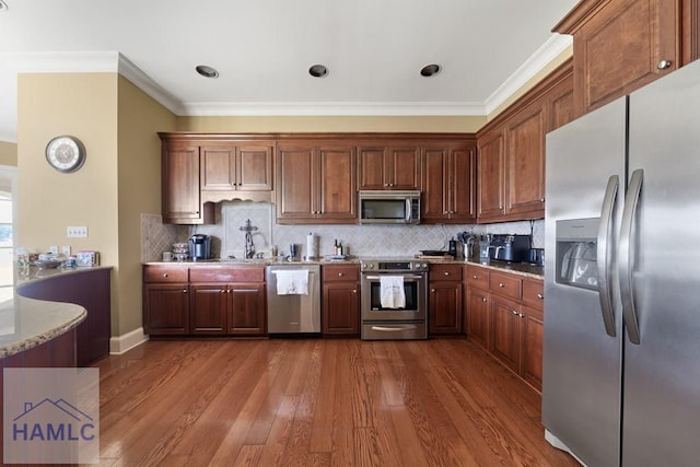 745 Chickasaw Trl, Sparta, GA 31087 - kitchen featuring stainless steel appliances, ornamental molding, dark wood-style flooring, backsplash, and light stone counters