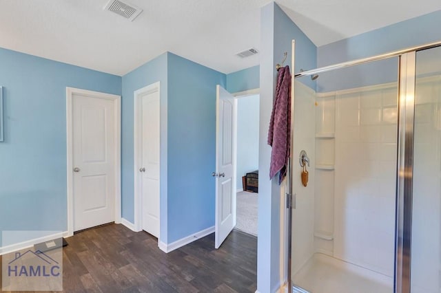 full bathroom with visible vents, a stall shower, baseboards, and wood finished floors