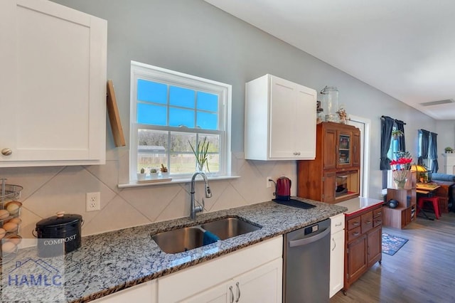 kitchen featuring backsplash, visible vents, stainless steel dishwasher, wood finished floors, and a sink