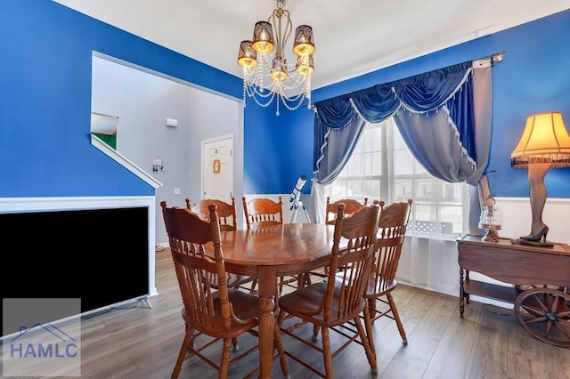 dining area with wood finished floors and a chandelier