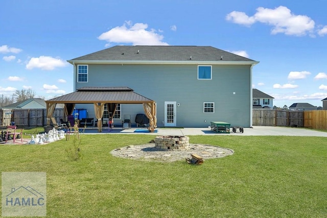 rear view of house with a gazebo, a fenced backyard, an outdoor fire pit, and a patio