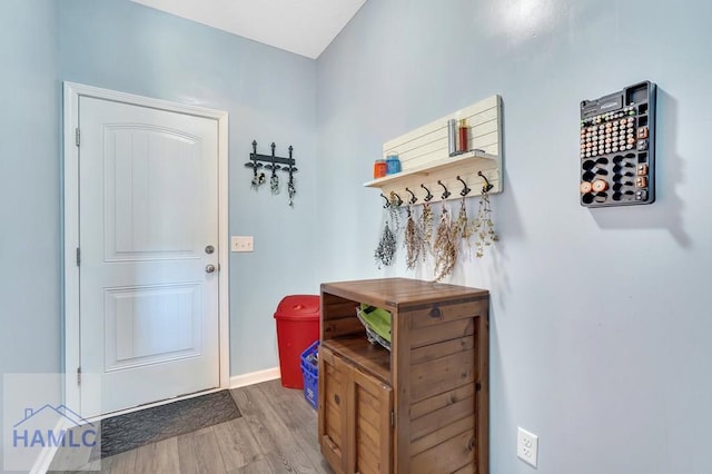 doorway to outside with baseboards and light wood-type flooring