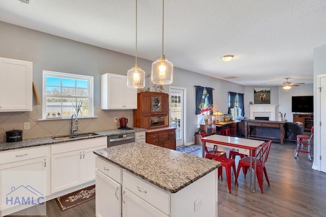 kitchen with a sink, decorative backsplash, a ceiling fan, and dishwasher