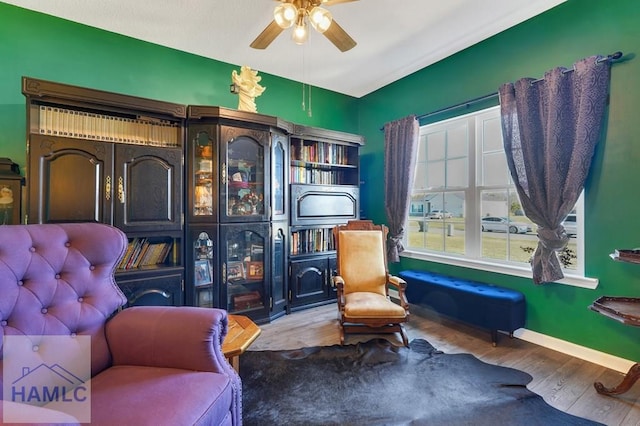 sitting room featuring baseboards, a ceiling fan, and wood finished floors