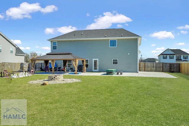 back of property with a gazebo, a fenced backyard, a yard, and a patio