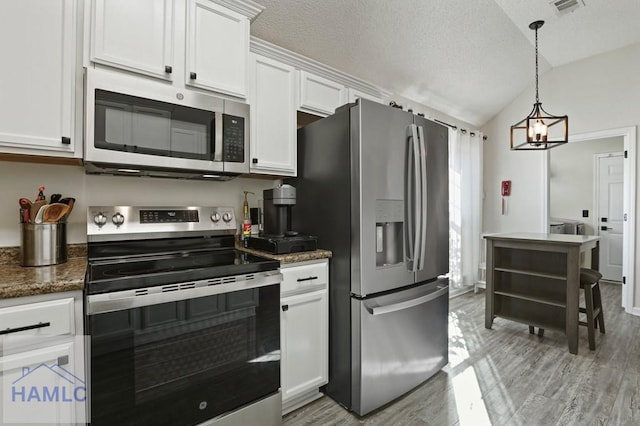 99 Scarlett Ln, Richmond Hill, GA 31324 - kitchen with stainless steel appliances, white cabinetry, vaulted ceiling, light wood finished floors, and a textured ceiling