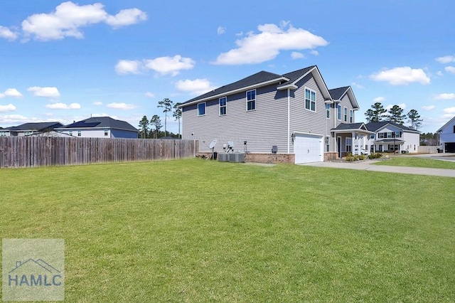 view of side of property with a yard, an attached garage, central AC, fence, and driveway