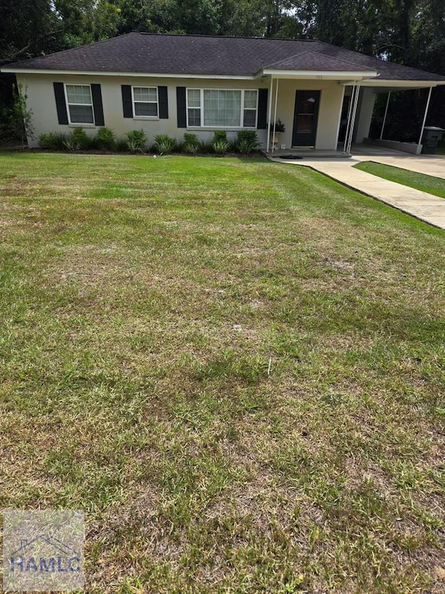155 Persimmon St, Jesup, GA 31545 - ranch-style house featuring an attached carport, concrete driveway, stucco siding, and a front lawn