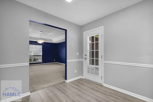 empty room with hardwood / wood-style floors and a tray ceiling