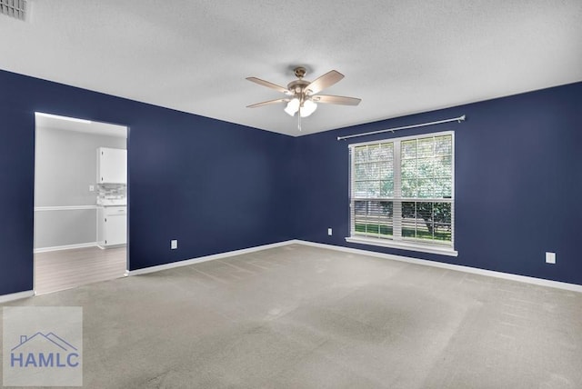 unfurnished room with carpet, ceiling fan, and a textured ceiling