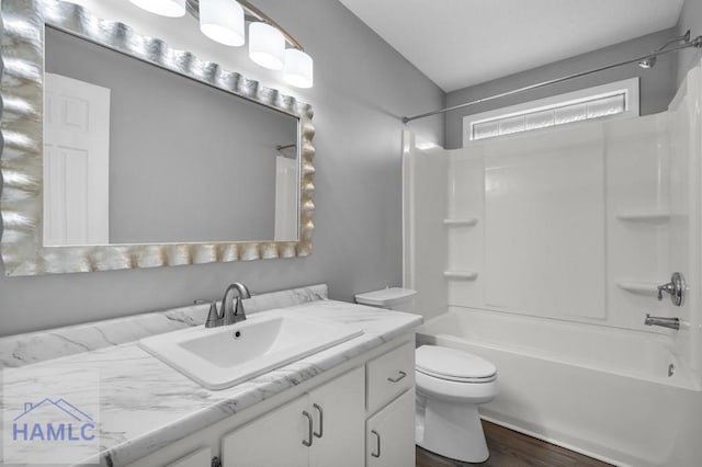 full bathroom with washtub / shower combination, toilet, vanity, and wood-type flooring