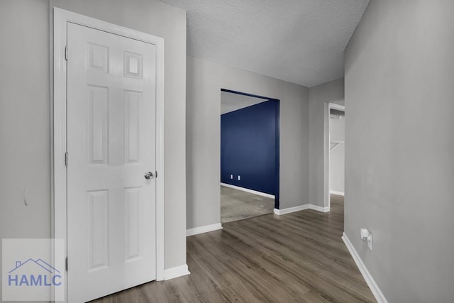 unfurnished room with hardwood / wood-style flooring and a textured ceiling