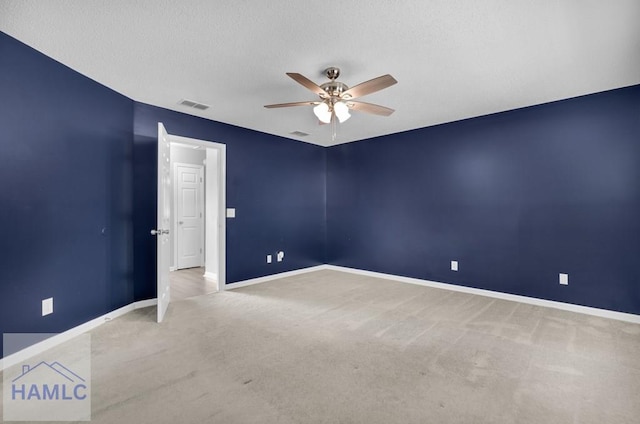 carpeted empty room featuring ceiling fan and a textured ceiling