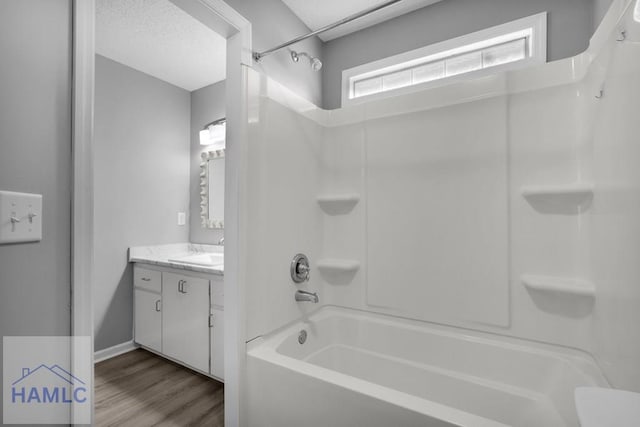 bathroom with hardwood / wood-style flooring, vanity, and bathtub / shower combination