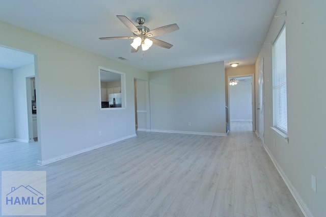 unfurnished room featuring ceiling fan, baseboards, visible vents, and light wood-style floors