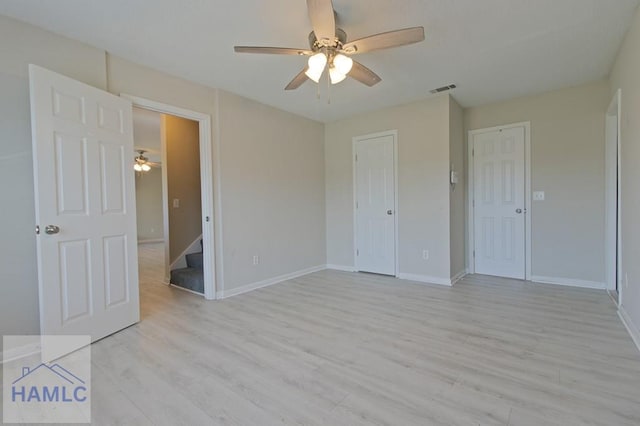 unfurnished bedroom featuring visible vents, baseboards, a ceiling fan, and light wood-style floors