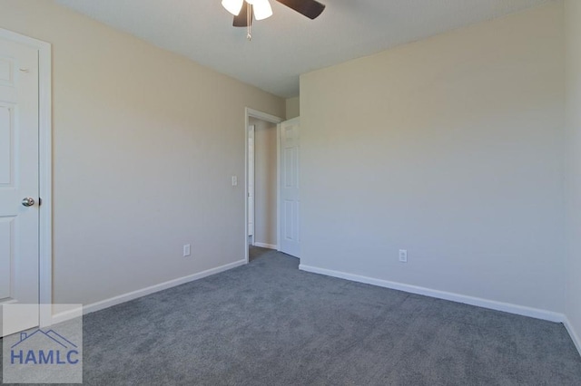empty room with ceiling fan, dark carpet, and baseboards