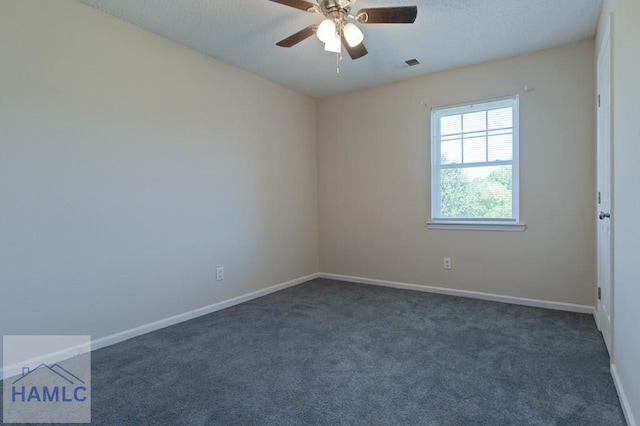unfurnished room featuring a ceiling fan, visible vents, dark carpet, and baseboards